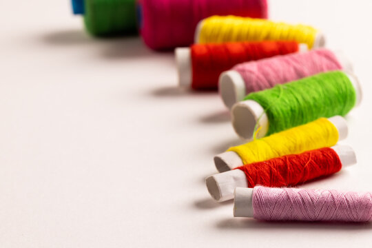 Composition of colourful sewing crewels on white background with copy space