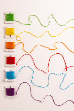 Composition of colourful sewing crewels on white background