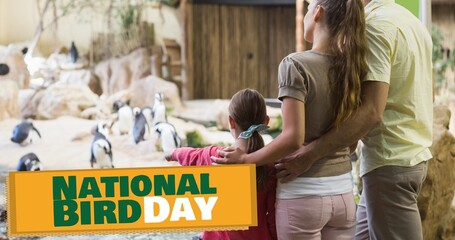 Composite of caucasian family looking at penguins at aquarium and national bird day text