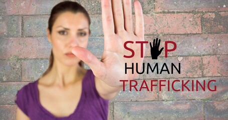 Composite of stop human trafficking text and caucasian serious woman showing stop sign against wall