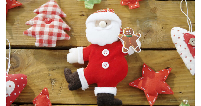 Image of santa and decorations on wooden background at christmas