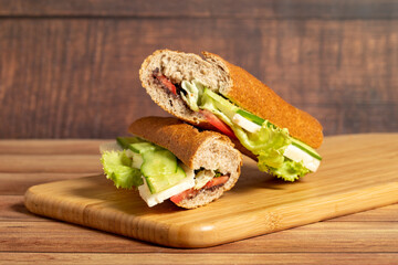 Baguette sandwich. Sandwich with olives, lettuce, tomato, cucumber, cheddar and feta cheese on...