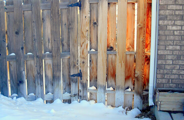 Snow covered fence outdoors.