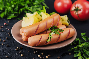 boiled sausages with potatoes on plate