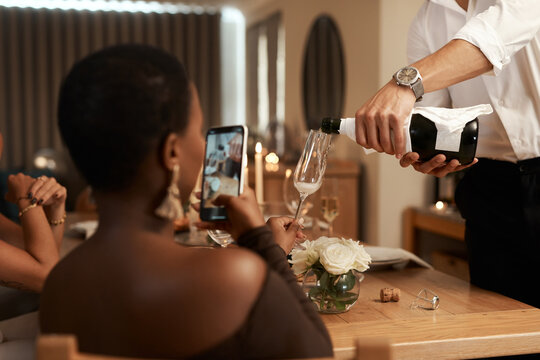 Phone, black woman or hands pouring champagne at a New Years dinner party, Christmas or social event. Content creation, content creator or influencer live streaming drinks or alcohol in wine glass