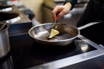chef frying butter in pan at kitchen