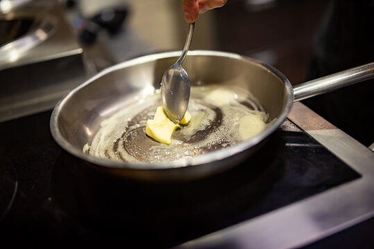 chef frying butter in pan at kitchen