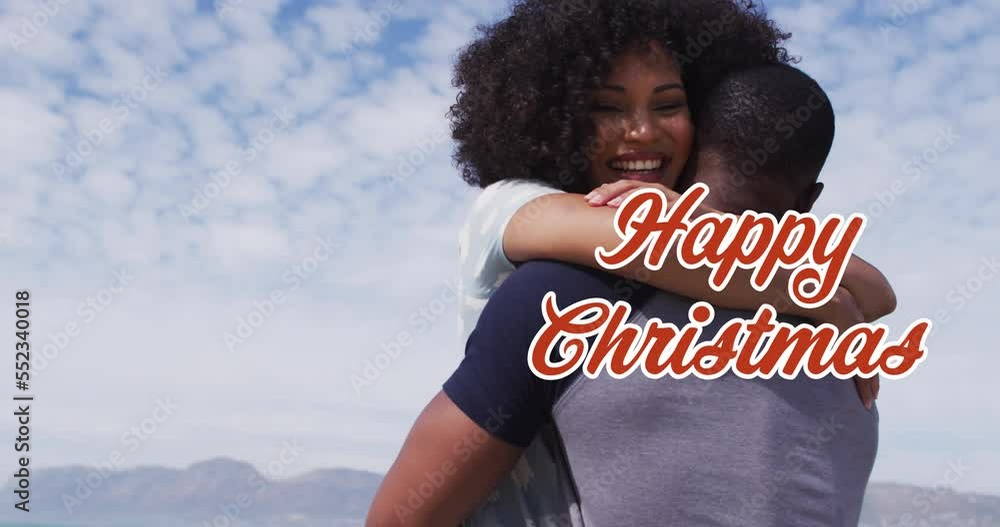 Sticker Animation of christmas greetings text over diverse couple on beach