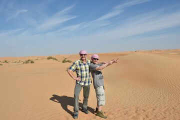 Männer posieren in der Sandwüste von Dubai 