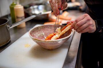 Close up hand of chef in restaurant cooking crab leg