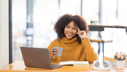 Young beautiful african student girl working, learning in computer and device studying online.