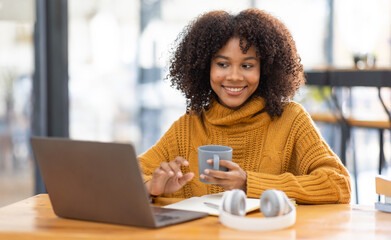 Young beautiful african student girl working, learning in computer and device studying online.