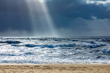 sea landscape with huge waves and a lightbeam in Sylt