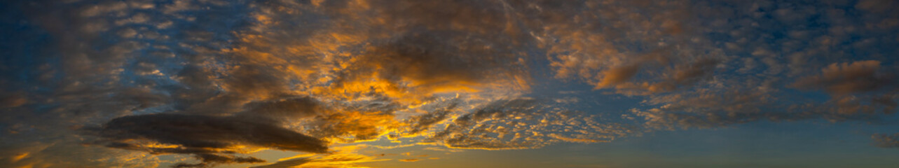 Panorama sunset sky and dark clouds.Fluffy cloud in the black sky background.Vivid sky on dark cloud before summer storm with dramatic light sky.