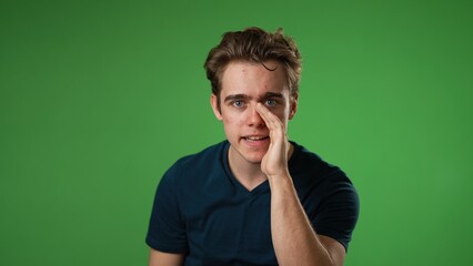 Portrait of caucasian hipster man 20s looks around put hand to mouth tells secret isolated on green screen background studio portrait  - Powered by Adobe