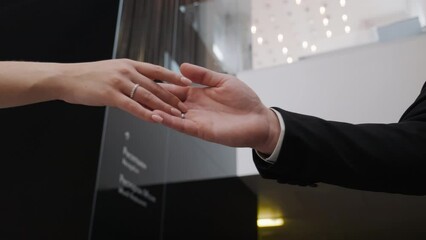 Bride and groom join hands with wedding rings in close up. Woman and man unite fingers, hold arms, touch, reaching out each other. Gesture sensual connecting of loving couple