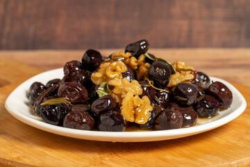 Mixed olives on wood background. Black olives prepared with walnuts and spices. Gourmet delicacies. close up