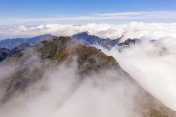 Drone view of mountain peak submerged in fog