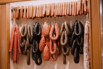 Assortment of smoked sausage and salami hanging in a supermarket. Delicacy and butchery shop