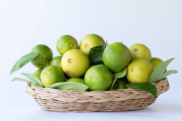 Green lemon in rattan basket for sell at market and supermarket.