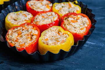 Stuffed pepper. Stewed pepper  with rice and minced meat. Baked peppers in a cast iron pan on a black background. Healthy Romanian food.