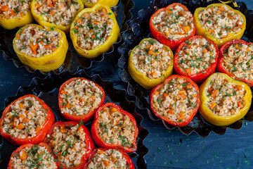 Stuffed pepper. Stewed pepper  with rice and minced meat. Baked peppers in a cast iron pan on a black background. Healthy Romanian food.