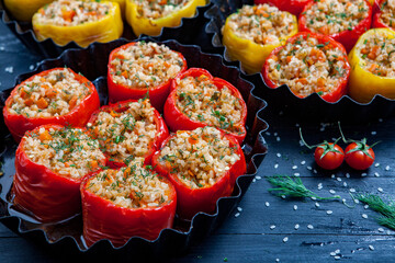 Stuffed pepper. Stewed pepper  with rice and minced meat. Baked peppers in a cast iron pan on a black background. Healthy Romanian food.