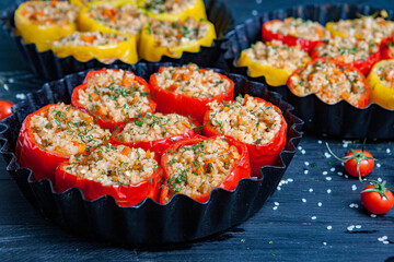 Stuffed pepper. Stewed pepper  with rice and minced meat. Baked peppers in a cast iron pan on a black background. Healthy Romanian food.