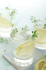 Glasses with lemon and thyme refreshing drink	