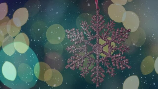 Animation of snow falling and light spots over christmas decorations