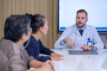 Caucasian male doctor consulting with an elderly Asian woman