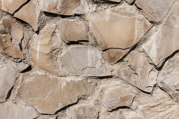 Bumpy stone surface. Beige stone wall background.