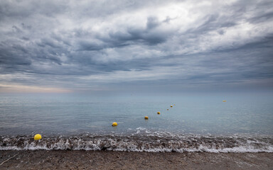 Row of buoys on the ocean against stormy sky