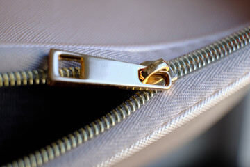 Selective focus, yellow metal zipper of a makeup bag or small purse macro pattern background