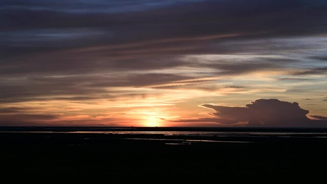 Sunset by the sea, with the sun setting below the horizontal line. Qingshui District, Gaomei Wetland, Taichung City, Taiwan