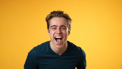 Portrait of laughing smiling happy young hipster man 20s isolated on solid yellow background with copy space in studio