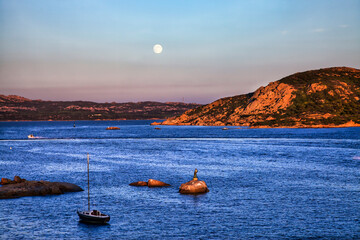 Moonrise at the sunset. La Maddalena harbour. Sardinia. Italy