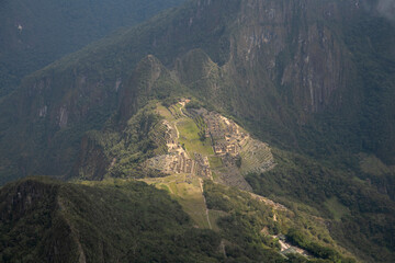Panoramic view of the ancient Inca city of Machu Picchu in the Sacred Valley in Peru with the Huayna Picchu mountain in the background covered by clouds.