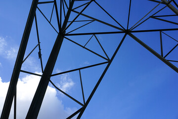 abstract shapes of an electric tower structure. close up of electricity pylons and blue sky backdrop. energy and power background 