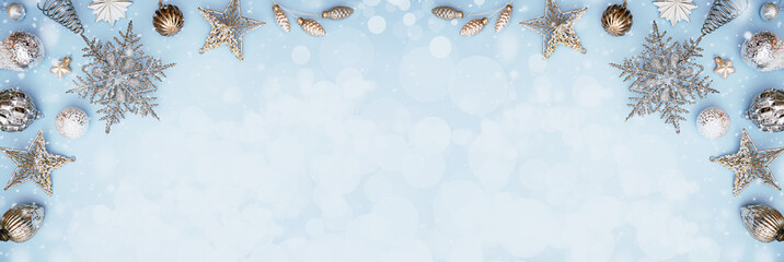 Merry Christmas and Happy New Year rich silver and crystal festive ornaments. stars glitter and Christmas baubles create border on baby blue background. Party decor snow. Top view copy space banner