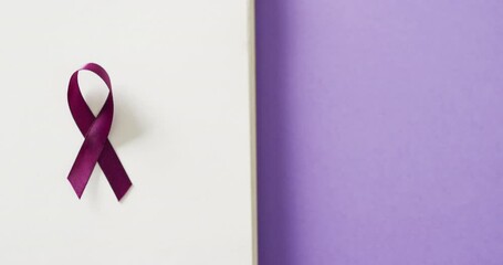 Video of purple add or adhd awareness ribbon on notebook, on purple background with copy space