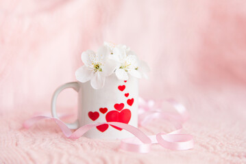 valentine's day concept. white cup for coffee with hearts on a pale pink background	