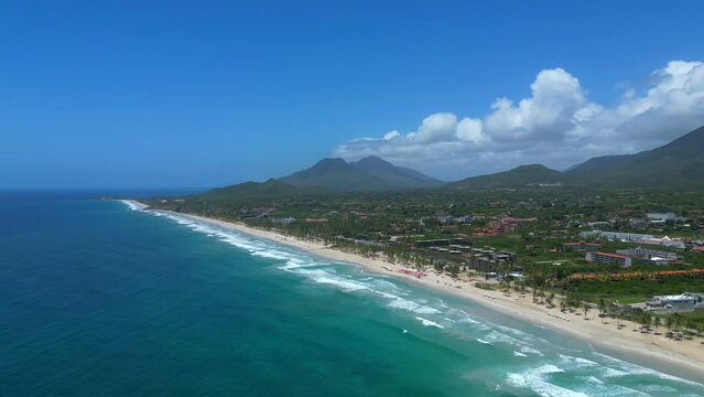 Aerial high view of the Margarita island and Playa El Agua tropical beach. Turquoise water of the Caribbean sea and mountains on background.