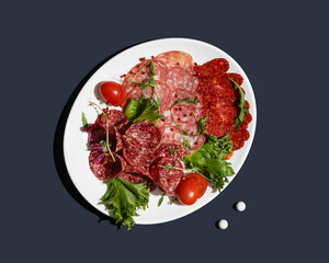 Appetizers with different antipasti, sausages snacks  on blue background. Sausage, ham, tapas  for buffet party. Top view, flat lay
