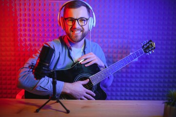 Obraz premium vlogger using smartphone to film podcast in studio. blogger with mobile phone, microphone and headphones filming video for social media broadcasting career.