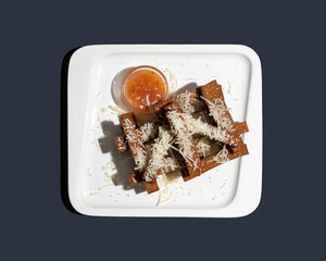 Bread croutons with parmesan in garlic for beer and sweet and sour sauce top view isolated on blue background