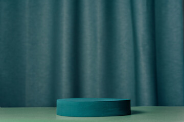 Oval teal podium, pedestal on a blue background with curtain. Empty showcase. Product, promotion...