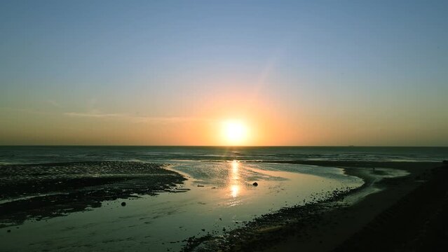 A complete record of the sunset horizon. The river flows into the sea. Xinwu District, Taoyuan City, Taiwan