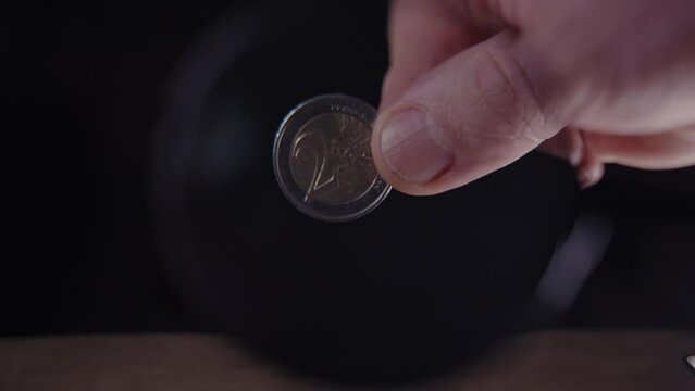 2 euro coin under a magnifying glass on a black background, coin authenticity check, close-up