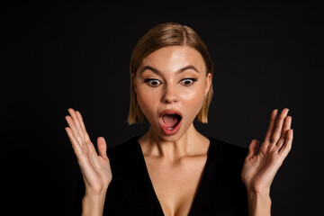 Young blond woman gesturing while expressing surprise at camera